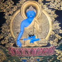 Tibetan thangka painting of the Medicine Buddha with blue skin and gold decorations on a black background
