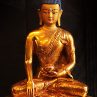 Statuette of Buddha meditating with blue hair and face painted with gold